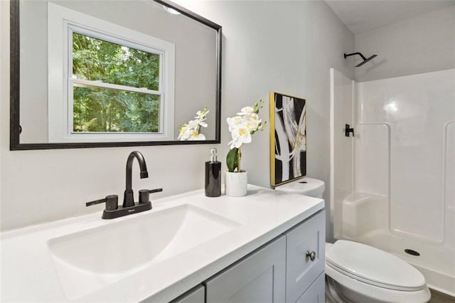 full bath featuring a shower, vanity, and toilet