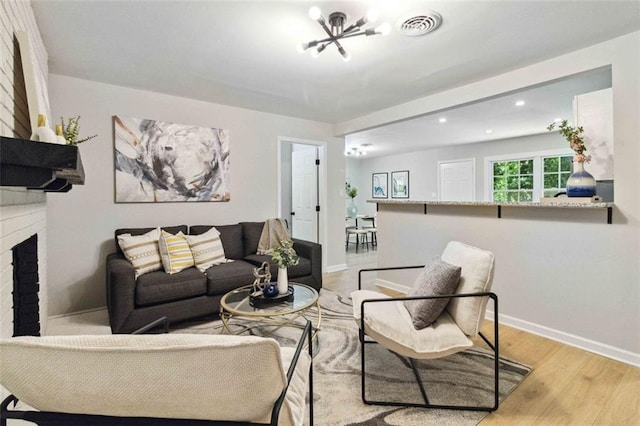 living room with recessed lighting, a fireplace, visible vents, baseboards, and light wood finished floors