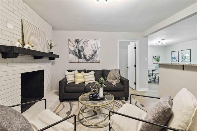 living area with a brick fireplace and light wood-style floors