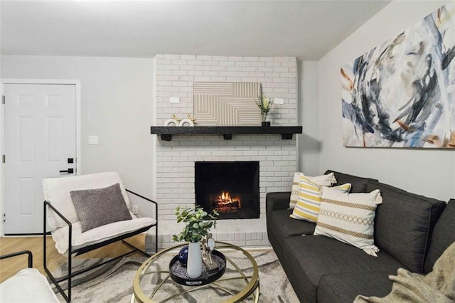 living room featuring light wood finished floors and a brick fireplace