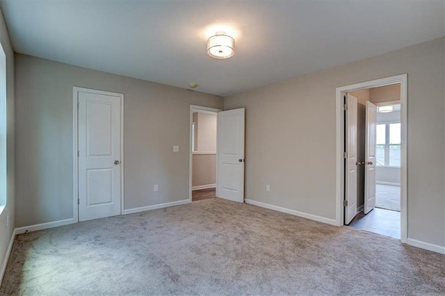 unfurnished bedroom with a closet and light carpet