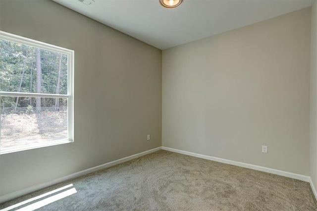 unfurnished room with light colored carpet and plenty of natural light