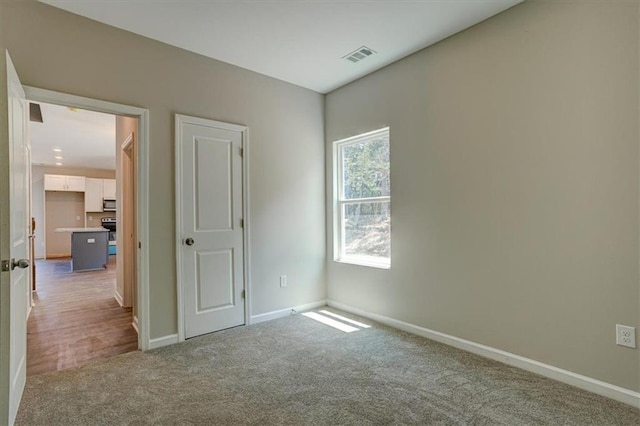 unfurnished room featuring light carpet