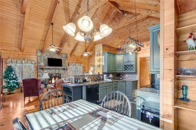 dining area featuring beam ceiling, ceiling fan, a stone fireplace, high vaulted ceiling, and wood ceiling