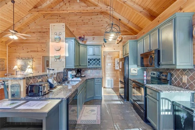 kitchen featuring beam ceiling, sink, decorative light fixtures, and black appliances