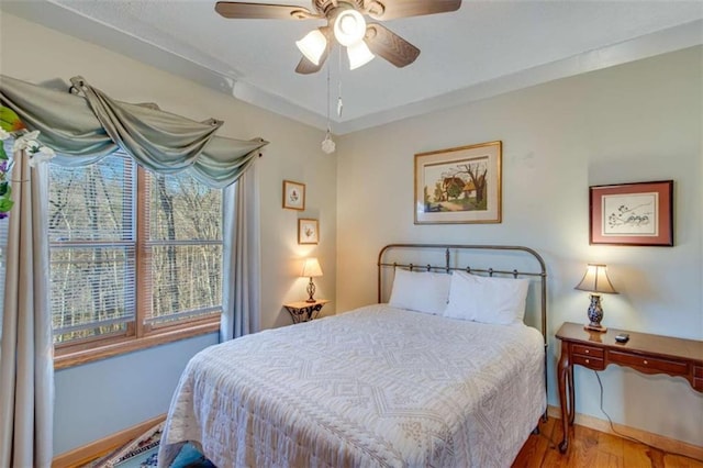 bedroom with hardwood / wood-style floors and ceiling fan