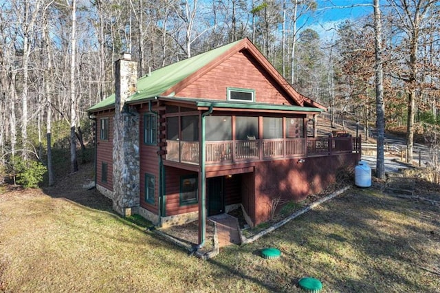 rear view of house with a sunroom and a lawn