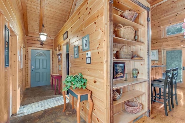 interior space with wood walls, lofted ceiling, and wooden ceiling