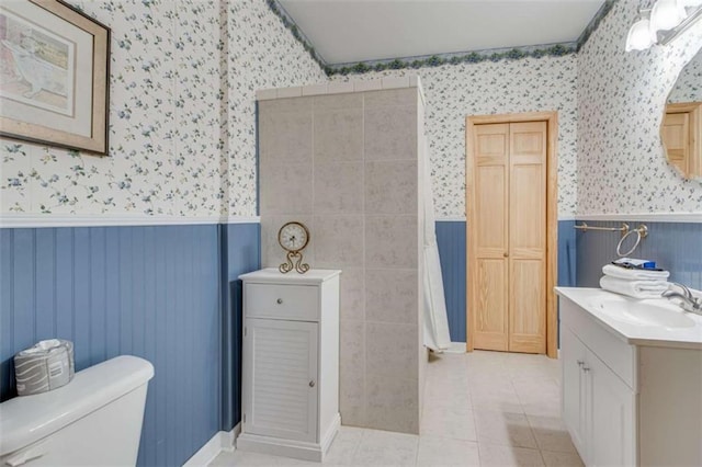 bathroom with tile patterned flooring, vanity, and toilet