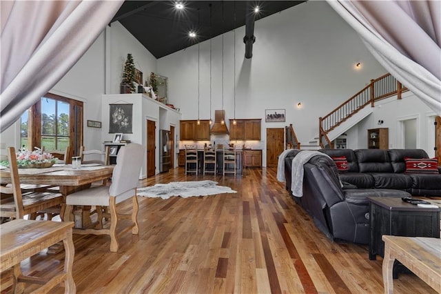 living room featuring wood-type flooring and high vaulted ceiling