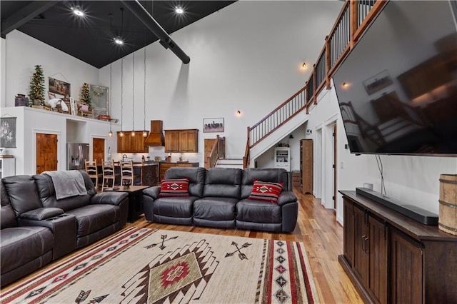 living room featuring a towering ceiling and light hardwood / wood-style floors