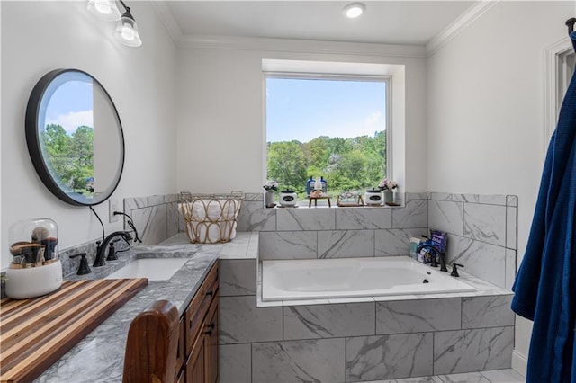 bathroom with tiled tub, crown molding, and vanity