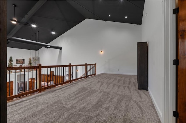 carpeted spare room featuring a towering ceiling