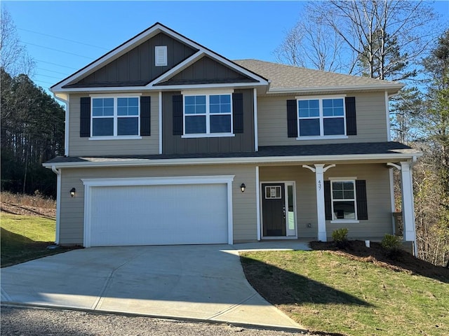 view of front of home with a front yard, a garage, and covered porch