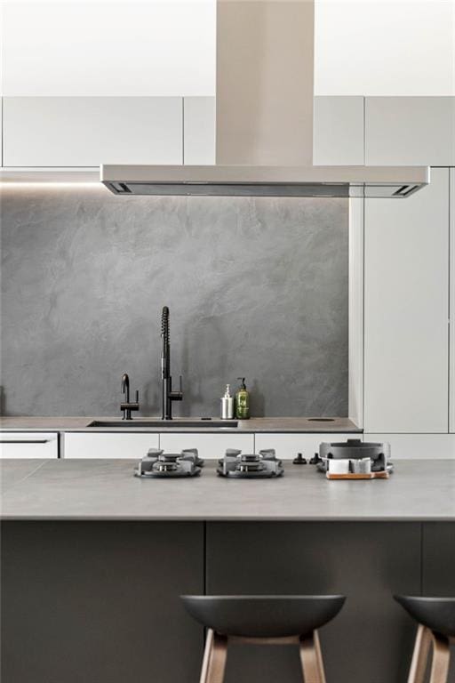 room details featuring white cabinets, light countertops, and exhaust hood