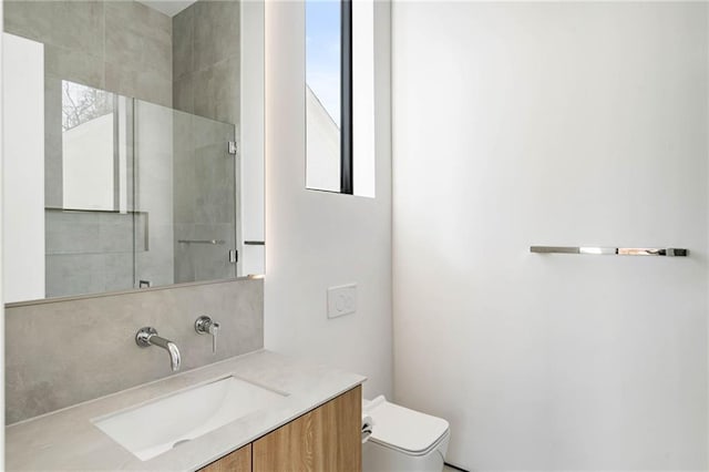 full bathroom featuring a wealth of natural light, backsplash, toilet, and vanity