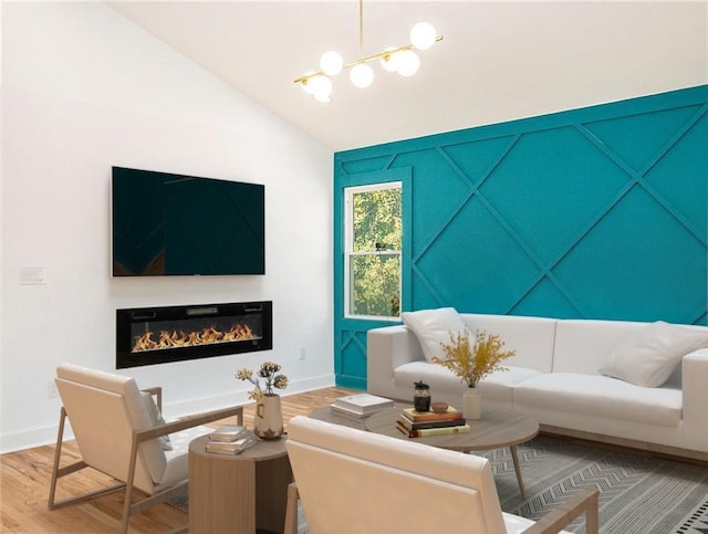 living room with a glass covered fireplace, wood finished floors, baseboards, lofted ceiling, and a chandelier