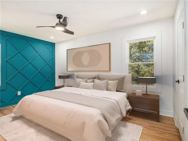 bedroom featuring light wood-type flooring, recessed lighting, baseboards, ceiling fan, and an accent wall