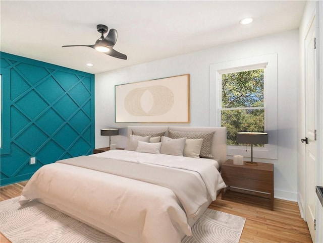 bedroom with light wood-type flooring, a ceiling fan, recessed lighting, baseboards, and an accent wall