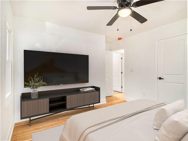 bedroom with light wood-style flooring, baseboards, and ceiling fan