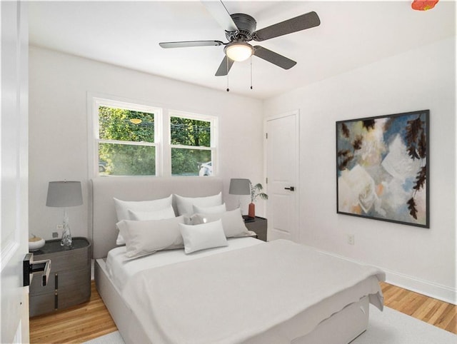 bedroom featuring light wood-type flooring, baseboards, and a ceiling fan