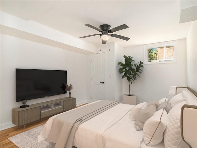 bedroom with baseboards, a ceiling fan, and wood finished floors