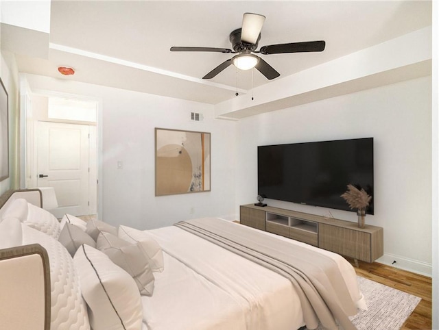 bedroom with visible vents, baseboards, ceiling fan, and wood finished floors