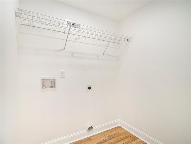 laundry area featuring light wood finished floors, baseboards, washer hookup, laundry area, and electric dryer hookup