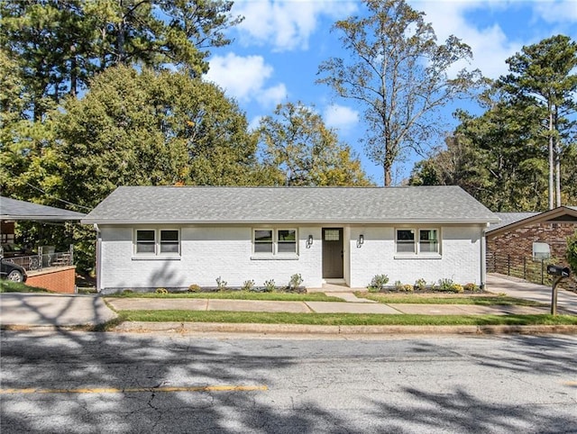 ranch-style house with brick siding and a shingled roof