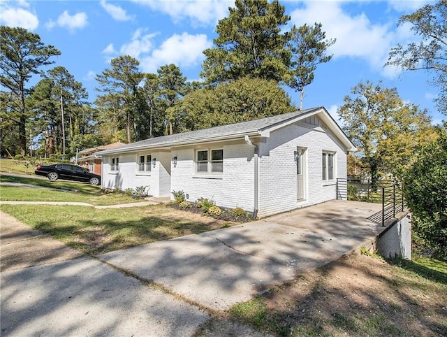 ranch-style house featuring brick siding and a front lawn