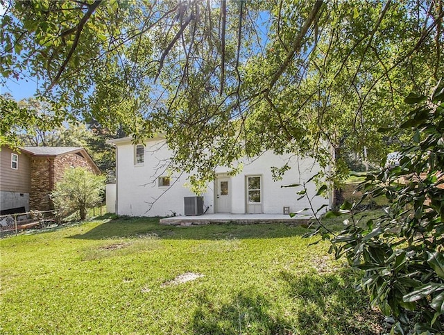 back of property featuring a patio area, central air condition unit, a lawn, and fence