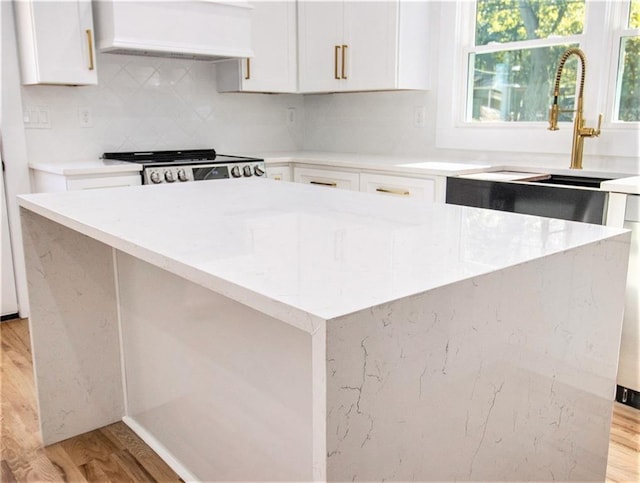 kitchen with custom exhaust hood, light stone counters, and stainless steel electric range oven