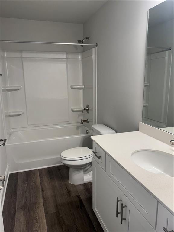 full bathroom with washtub / shower combination, hardwood / wood-style floors, vanity, and toilet