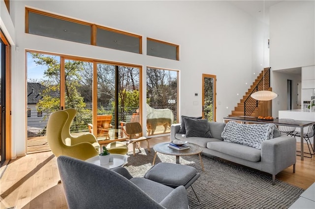 living room with a high ceiling and light wood-type flooring