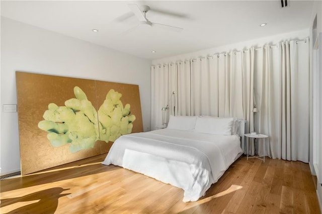 bedroom with hardwood / wood-style floors and ceiling fan