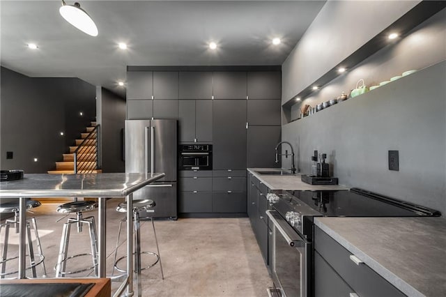 kitchen with appliances with stainless steel finishes, sink, and gray cabinetry