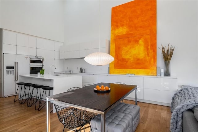 dining space with sink and light hardwood / wood-style floors