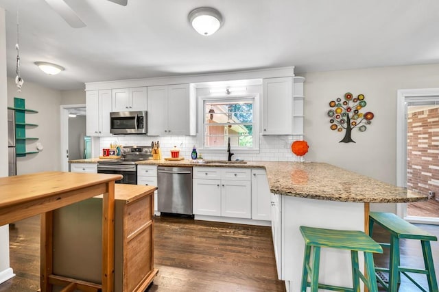 5400 Francis Ave, Stone Mountain, GA 30087 - kitchen featuring appliances with stainless steel finishes, a sink, a peninsula, and decorative backsplash