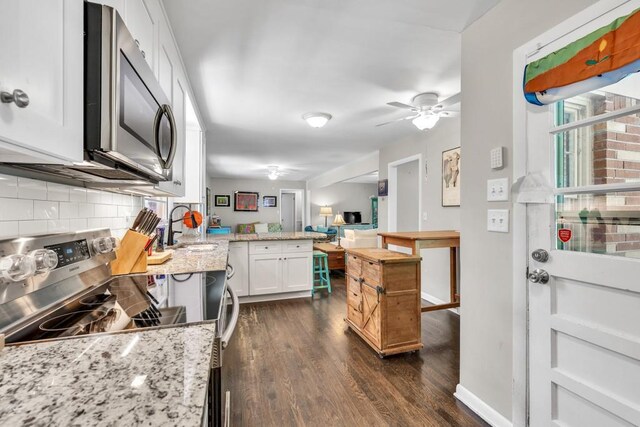 5400 Francis Ave, Stone Mountain, GA 30087 - kitchen with stainless steel appliances, a peninsula, backsplash, dark wood-type flooring, and white cabinets