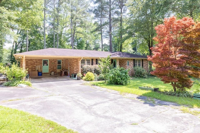 5400 Francis Ave, Stone Mountain, GA 30087 - single story home with a front lawn, a carport, driveway, brick siding, and view of wooded area