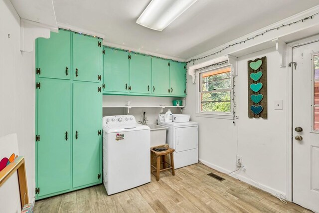 5400 Francis Ave, Stone Mountain, GA 30087 - laundry room with cabinet space, washer and dryer, and light wood finished floors