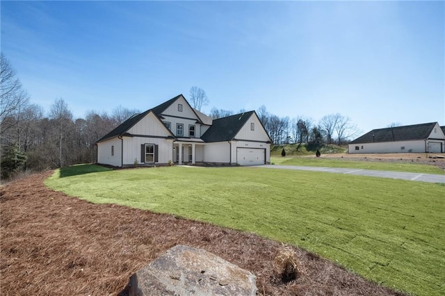 view of front of property with board and batten siding, a front yard, driveway, and an attached garage