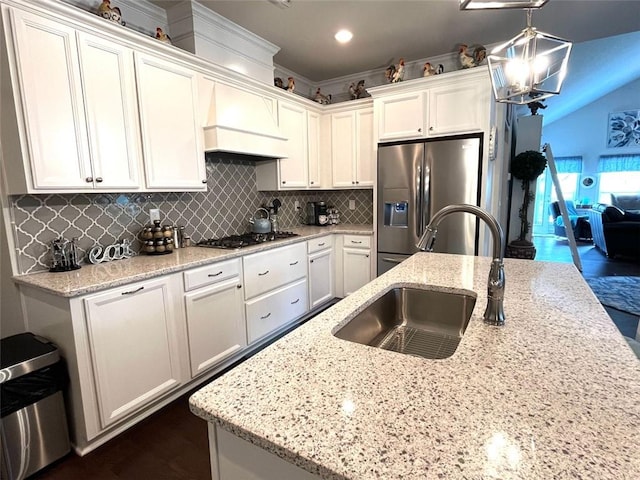 kitchen with white cabinets, stainless steel appliances, and vaulted ceiling