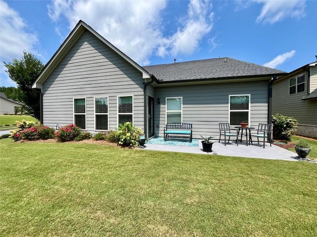 rear view of property featuring a patio area and a yard