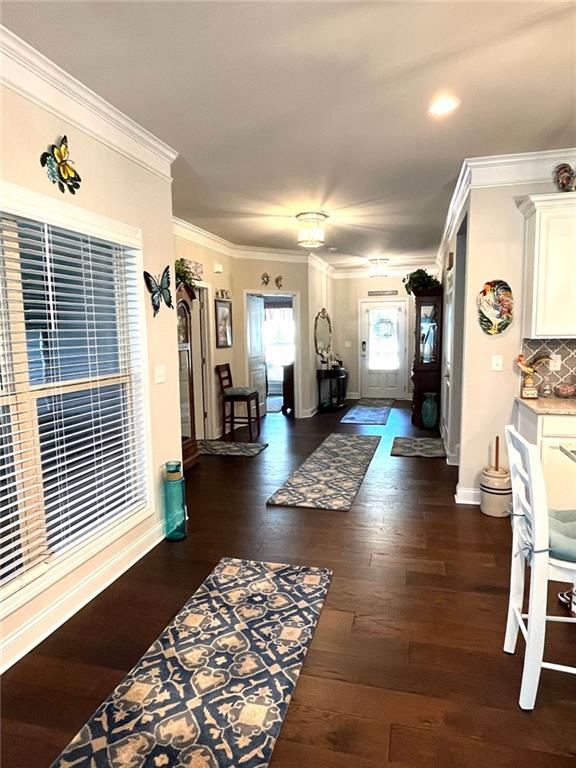 entrance foyer featuring ornamental molding and dark hardwood / wood-style flooring