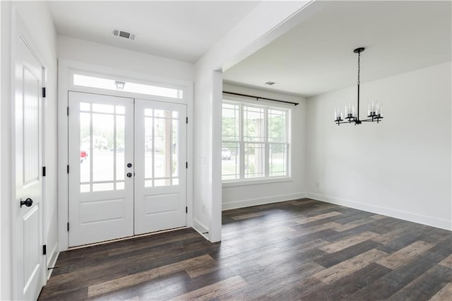 foyer entrance featuring french doors, a notable chandelier, and dark hardwood / wood-style floors