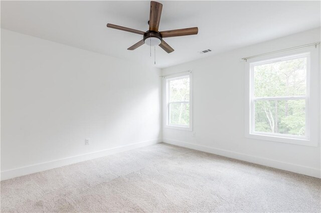 empty room with ceiling fan, carpet floors, and a healthy amount of sunlight