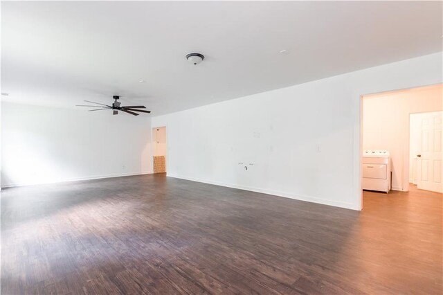 empty room with washer / clothes dryer, ceiling fan, and dark hardwood / wood-style flooring