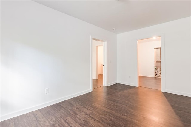 unfurnished room with dark wood-type flooring