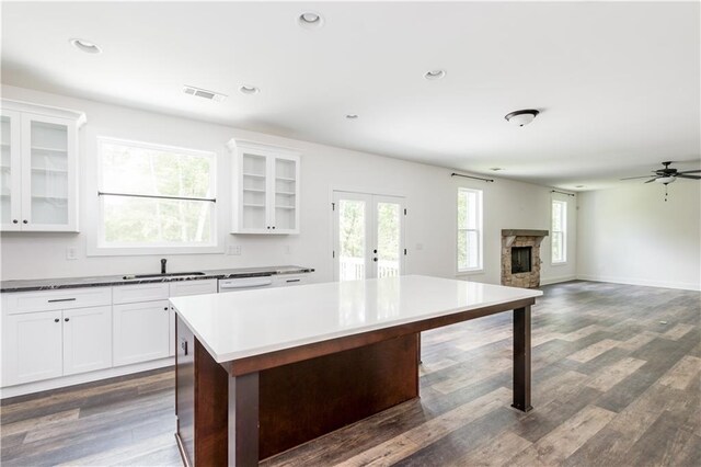 kitchen featuring a fireplace, dark hardwood / wood-style floors, and white cabinetry